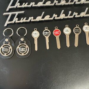 TEN PIECES OF 1956 THUNDERBIRD EMBLEMS,KEY BLANKS, 2 KEY HOLDERS NEW!